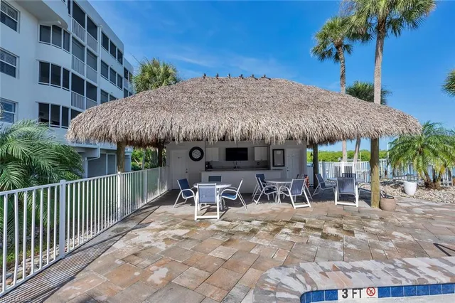 a patio with a table and chairs under an umbrella