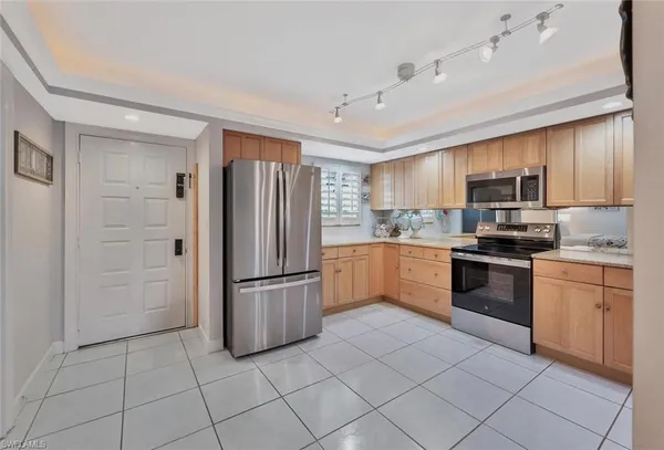 a kitchen with granite countertop a refrigerator and a stove top oven