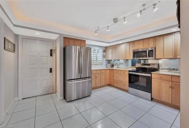 a kitchen with granite countertop a refrigerator and a stove top oven