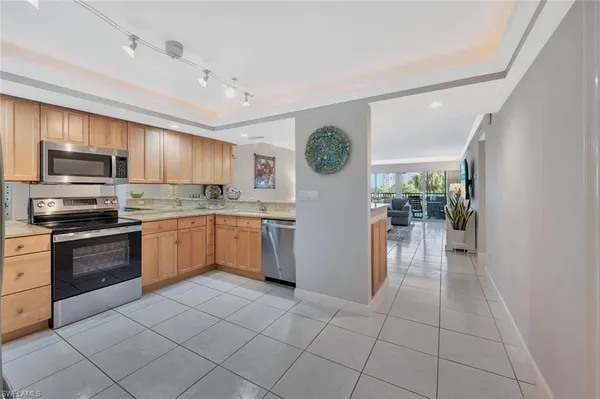 a kitchen with granite countertop a refrigerator and a stove top oven