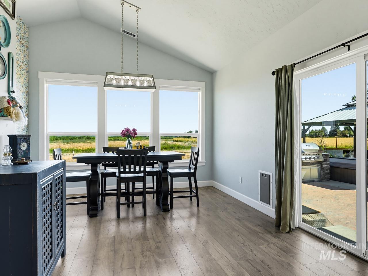 4950 West Columbia Road Nampa, ID 83687 - Photo 18 of 50 Dining area with vaulted ceiling, wood-finish flooring, and a linear chandelier