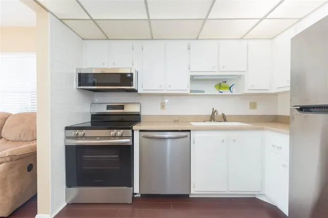 a kitchen with stainless steel appliances granite countertop a stove a sink and a microwave