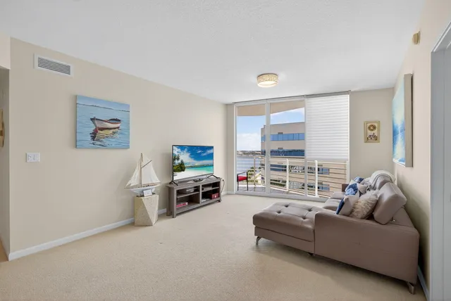 a living room with furniture a window and a flat screen tv