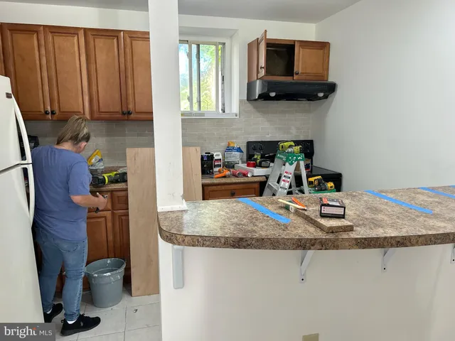 a kitchen with stainless steel appliances granite countertop a refrigerator a stove top oven a sink and dishwasher