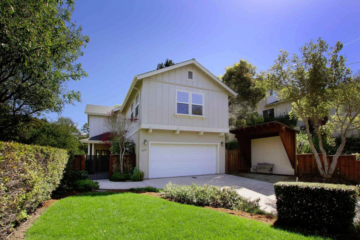 a front view of a house with a garden and trees