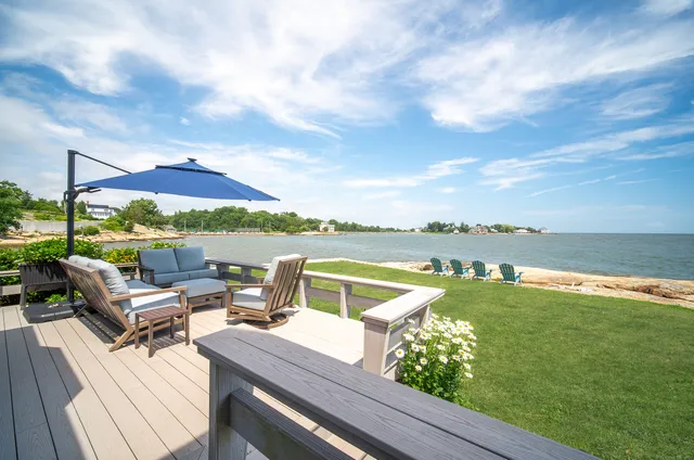 a view of a lake with couches chairs and city view