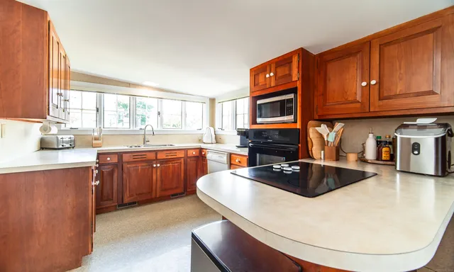 a kitchen with granite countertop a sink a counter space appliances and cabinets