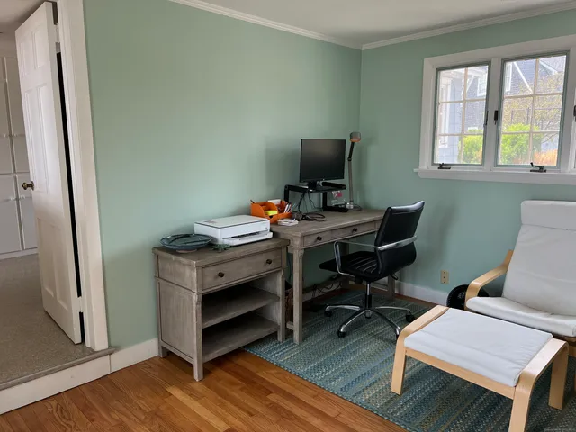 a view of a workspace with furniture and a window