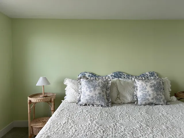 a large bed sitting in a bedroom next to a wall