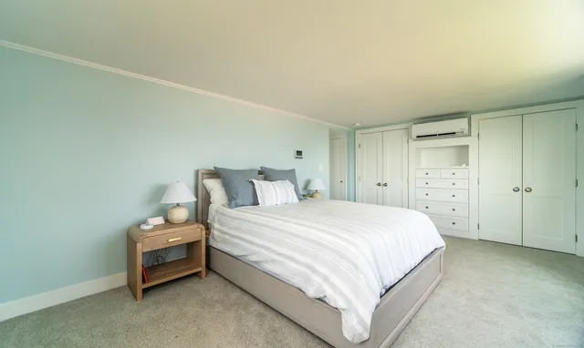 a spacious bedroom with a bed and a cabinets