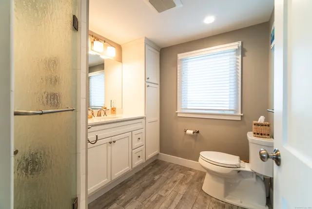 a bathroom with a toilet a sink and a window