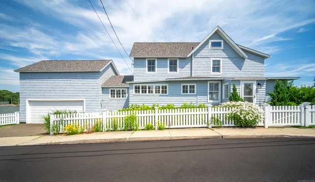 a front view of a house with a garden and plants