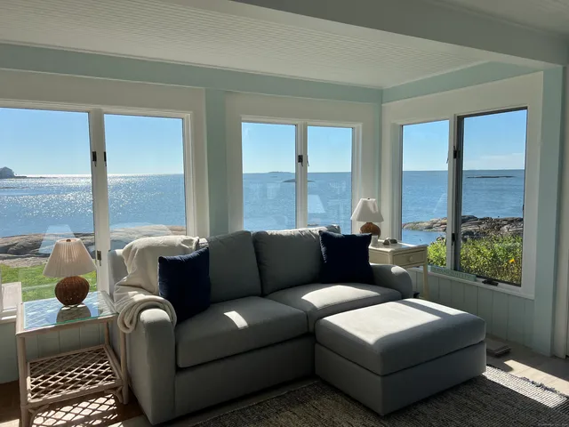 a living room with furniture and a floor to ceiling window