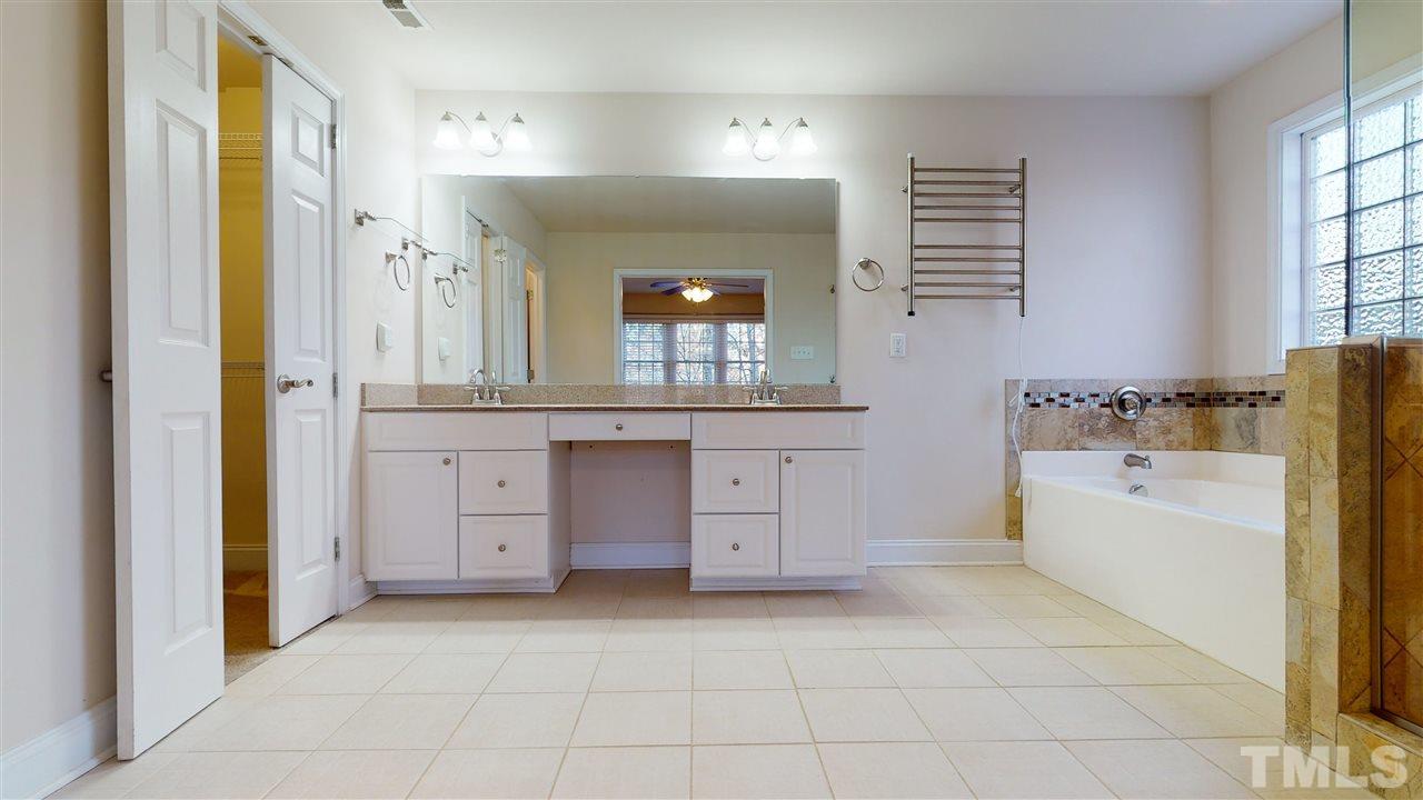 2105 Cook Road Durham, NC 27713 - Photo 16 of 29 a bathroom with a granite countertop sink a toilet a mirror a vanity and window