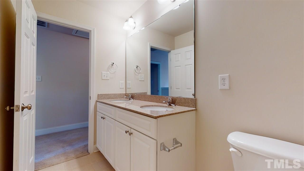 2105 Cook Road Durham, NC 27713 - Photo 8 of 29 a bathroom with a granite countertop sink a toilet and a mirror