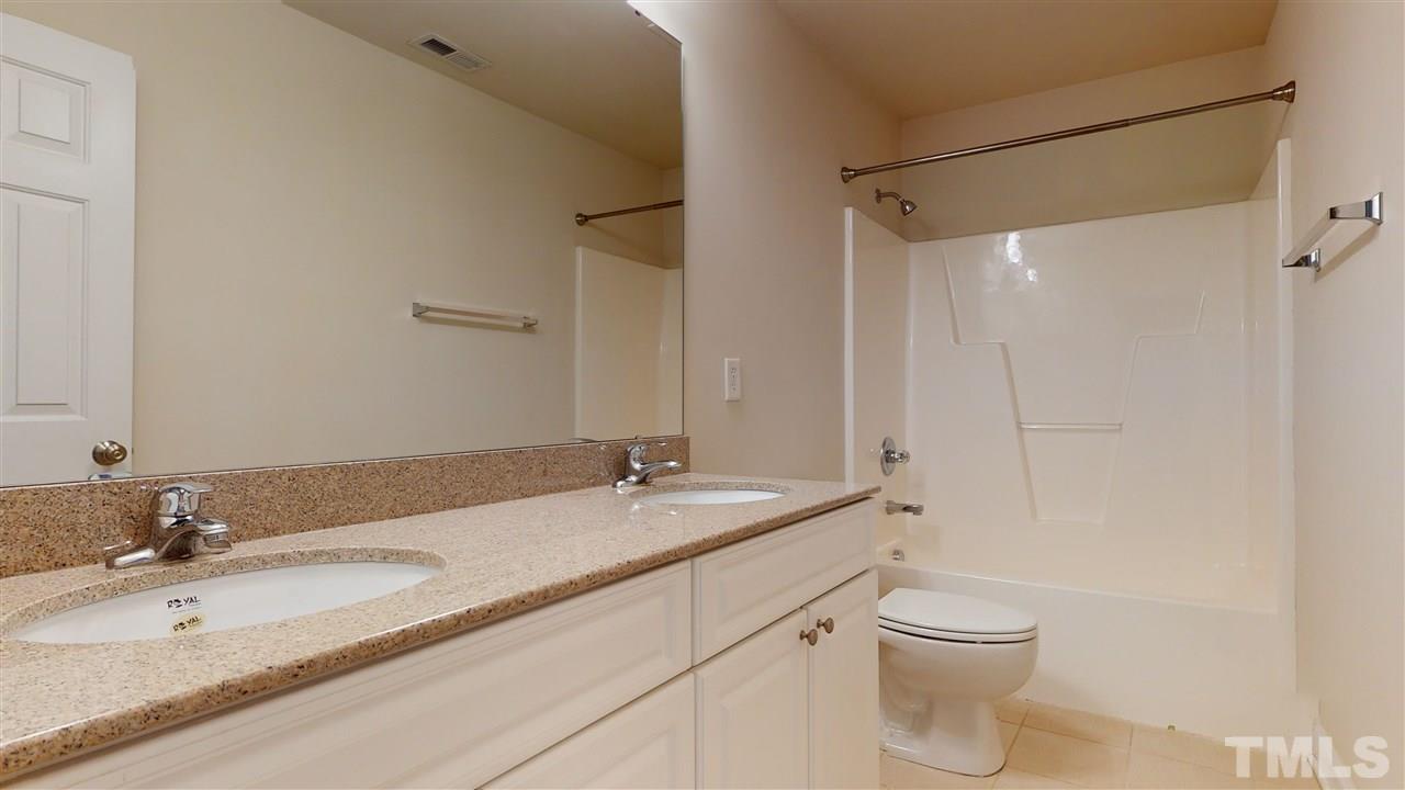 2105 Cook Road Durham, NC 27713 - Photo 9 of 29 a bathroom with a granite countertop sink a toilet and a mirror