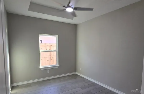 an empty room with a window and wooden floor
