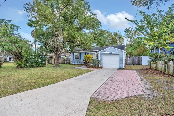 a front view of a house with a yard and trees