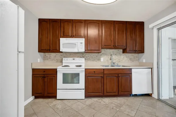 a kitchen with stainless steel appliances granite countertop wooden cabinets and a stove top oven