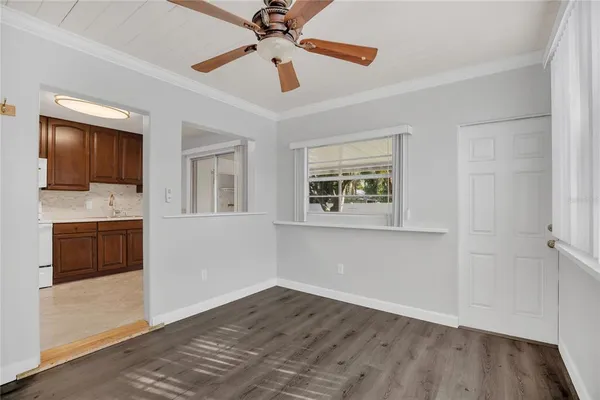 a view of a kitchen with wooden floor and a ceiling fan