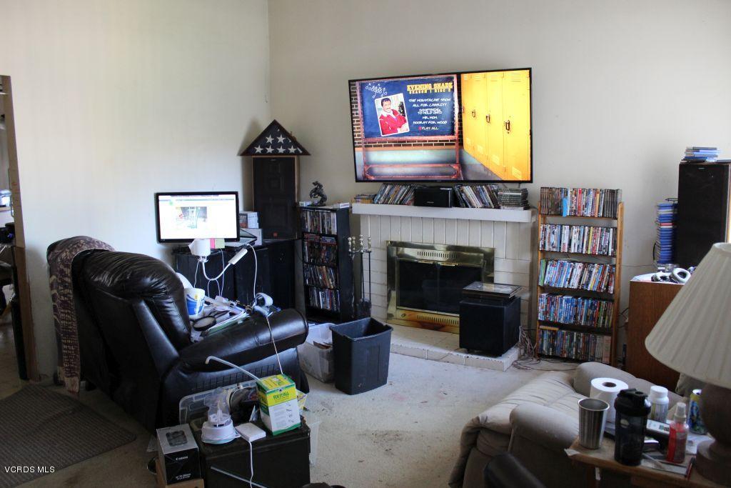 13433 Laurelhurst Road Moorpark, CA 93021 - Photo 3 of 23 a living room with furniture a fireplace and a flat screen tv