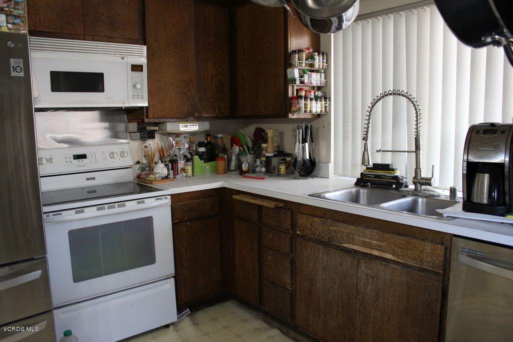 13433 Laurelhurst Road Moorpark, CA 93021 - Photo 7 of 23 a kitchen with stainless steel appliances granite countertop a stove a sink and a microwave