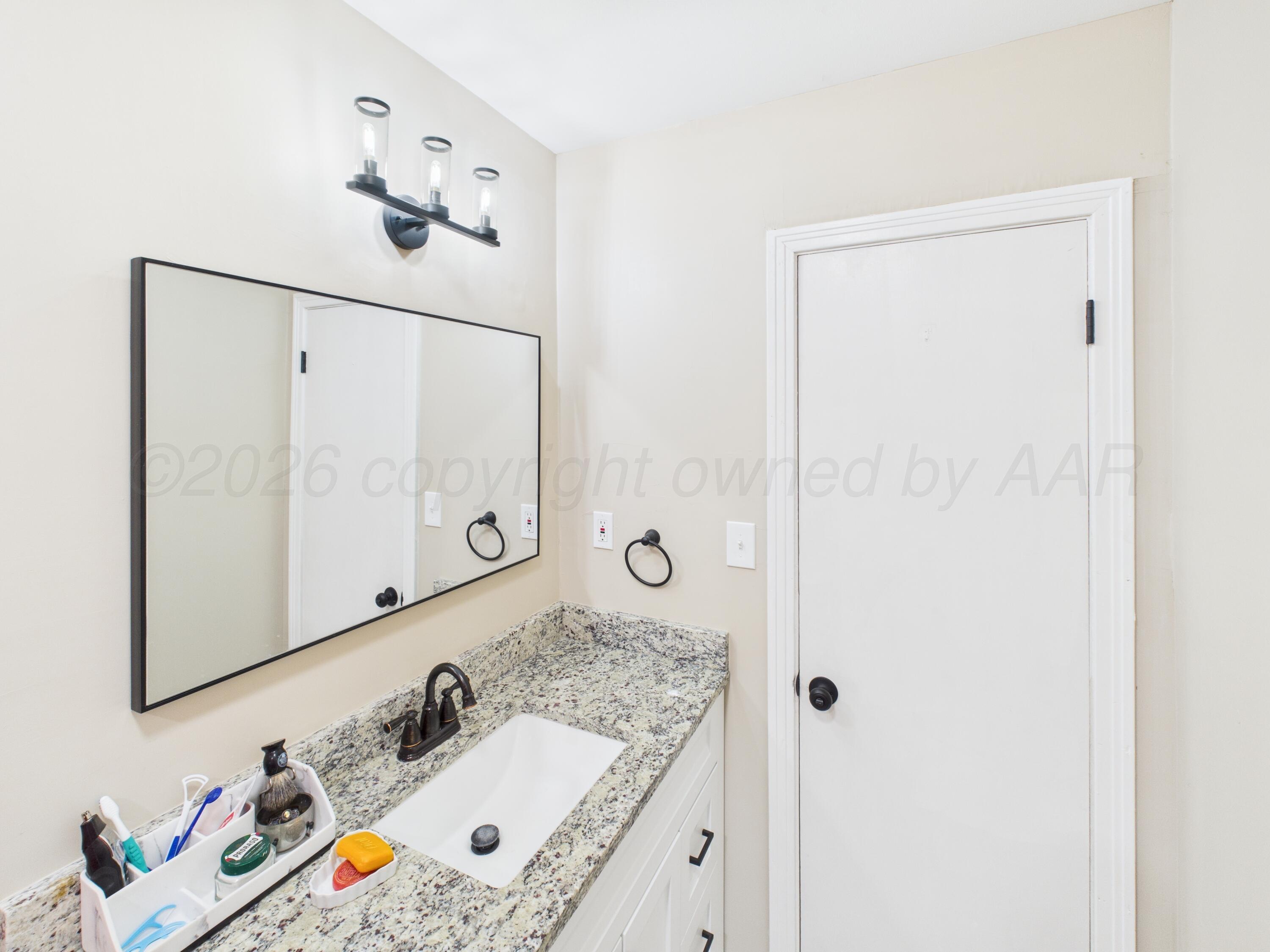 1816 Tularosa Street Amarillo, TX 79102 - Photo 8 of 24 a bathroom with a sink vanity and mirror