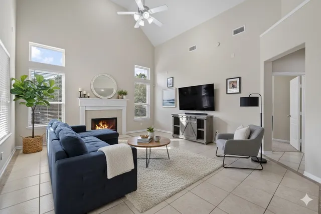 a living room with furniture a flat screen tv and a fireplace