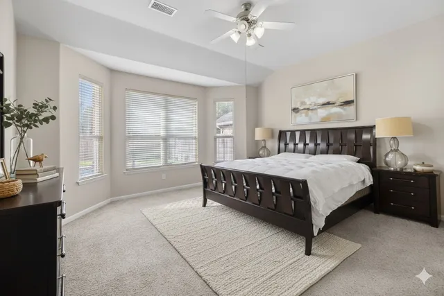 a bedroom with a large bed and a chandelier