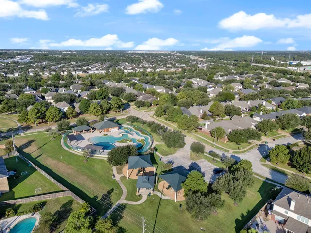 view of a swimming pool with a yard and plants