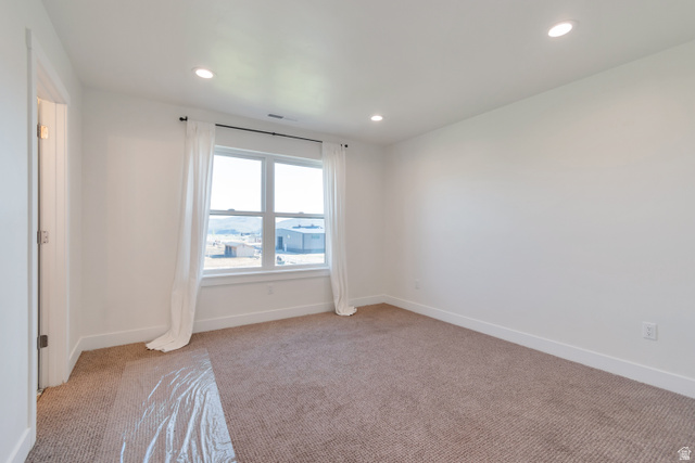 1820 West Farmhouse Flats Road Peoa, UT 84061 - Photo 32 of 79 Spacious room featuring a large window, recessed lighting, neutral carpet flooring, white walls, and a white trim baseboard