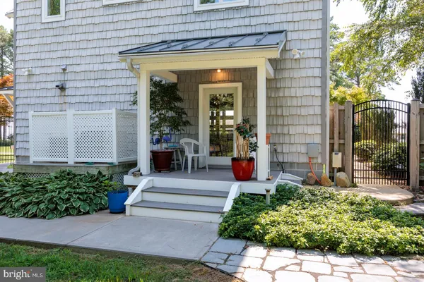 a view of a house with potted plants and a fountain