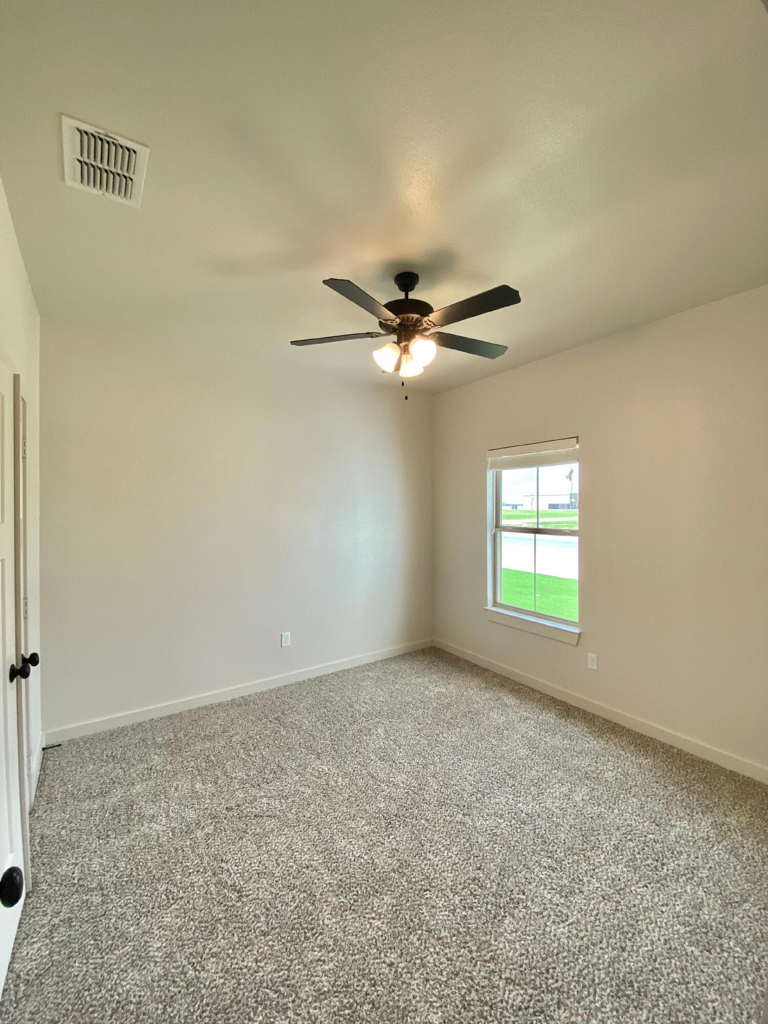 2725 137th Street Lubbock, TX 79423 - Photo 8 of 17 an empty room with windows and fan