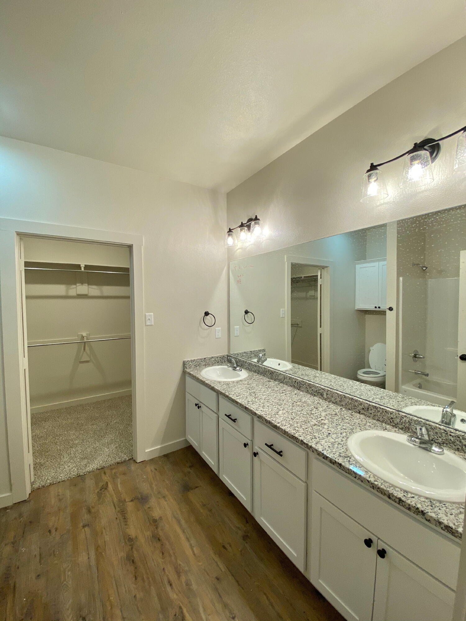 2725 137th Street Lubbock, TX 79423 - Photo 10 of 17 a bathroom with a granite countertop sink a mirror and a shower
