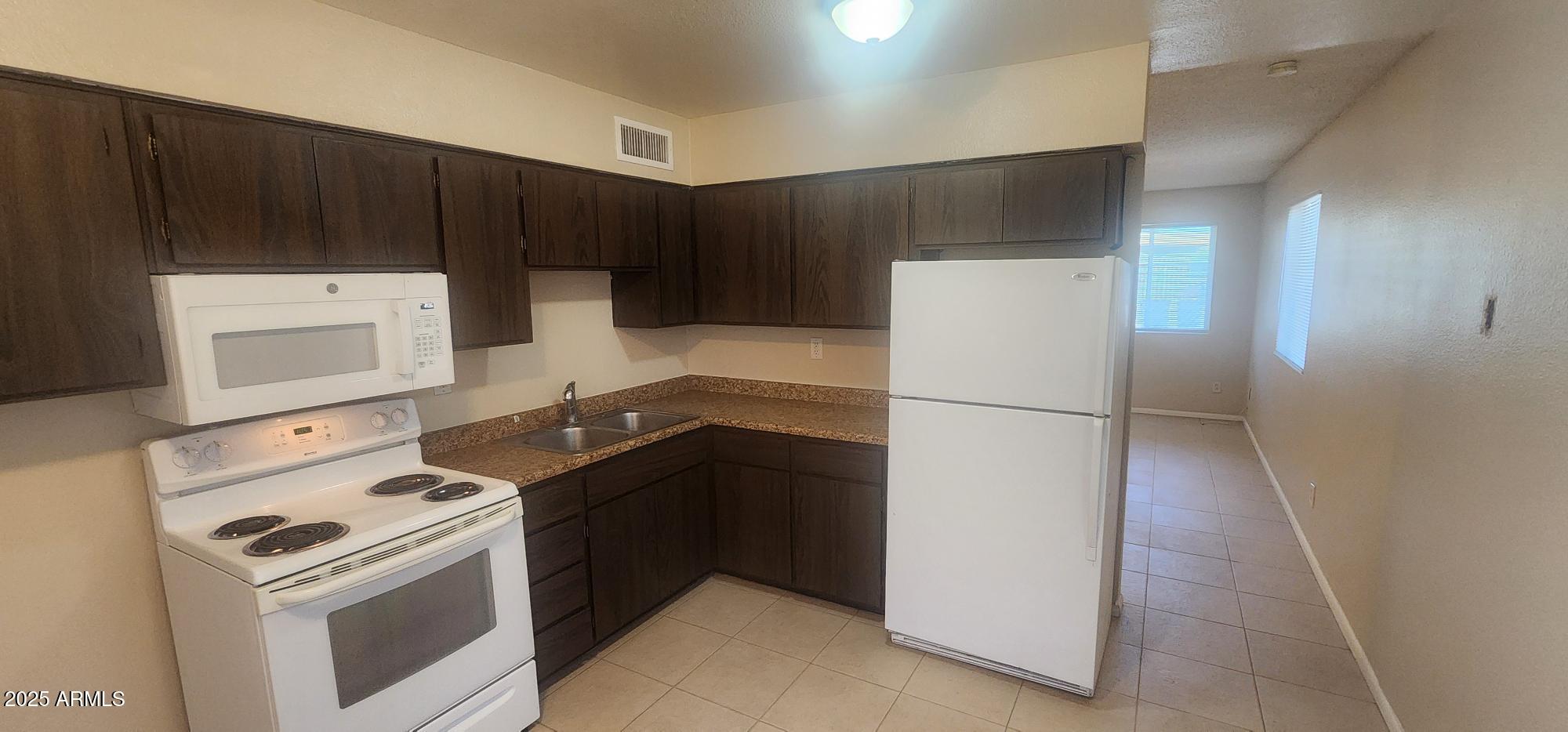 8322 North 60th Avenue, Unit 1 Glendale, AZ 85302 - Photo 29 of 37 a kitchen with a stove refrigerator and cabinets