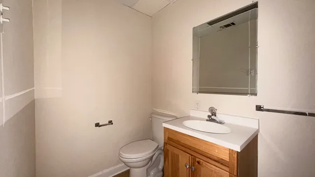 a bathroom with a sink toilet and mirror