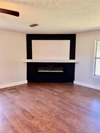 a view of a room with a ceiling fan and window