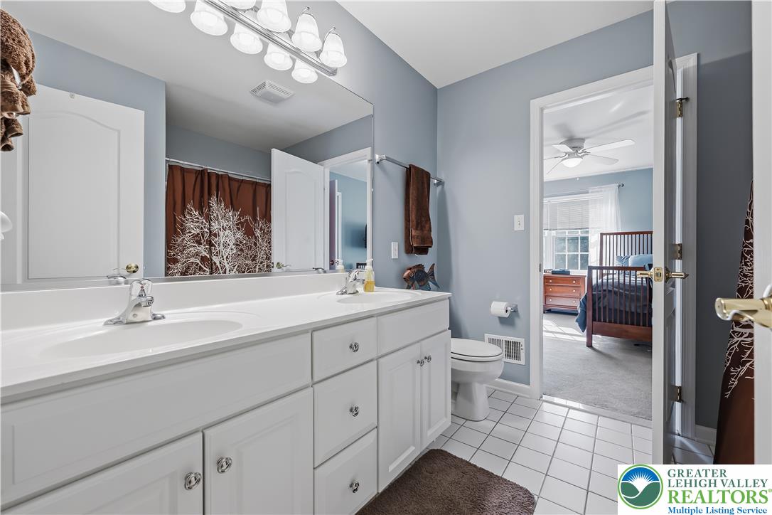 13 Country Road Northampton, PA 18067 - Photo 43 of 71 Double vanity in a well-lit bathroom, offering convenient access to an adjoining bedroom.