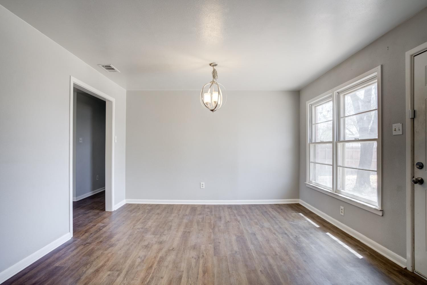 3011 44th Street Lubbock, TX 79413 - Photo 4 of 19 wooden floor in an empty room with a window