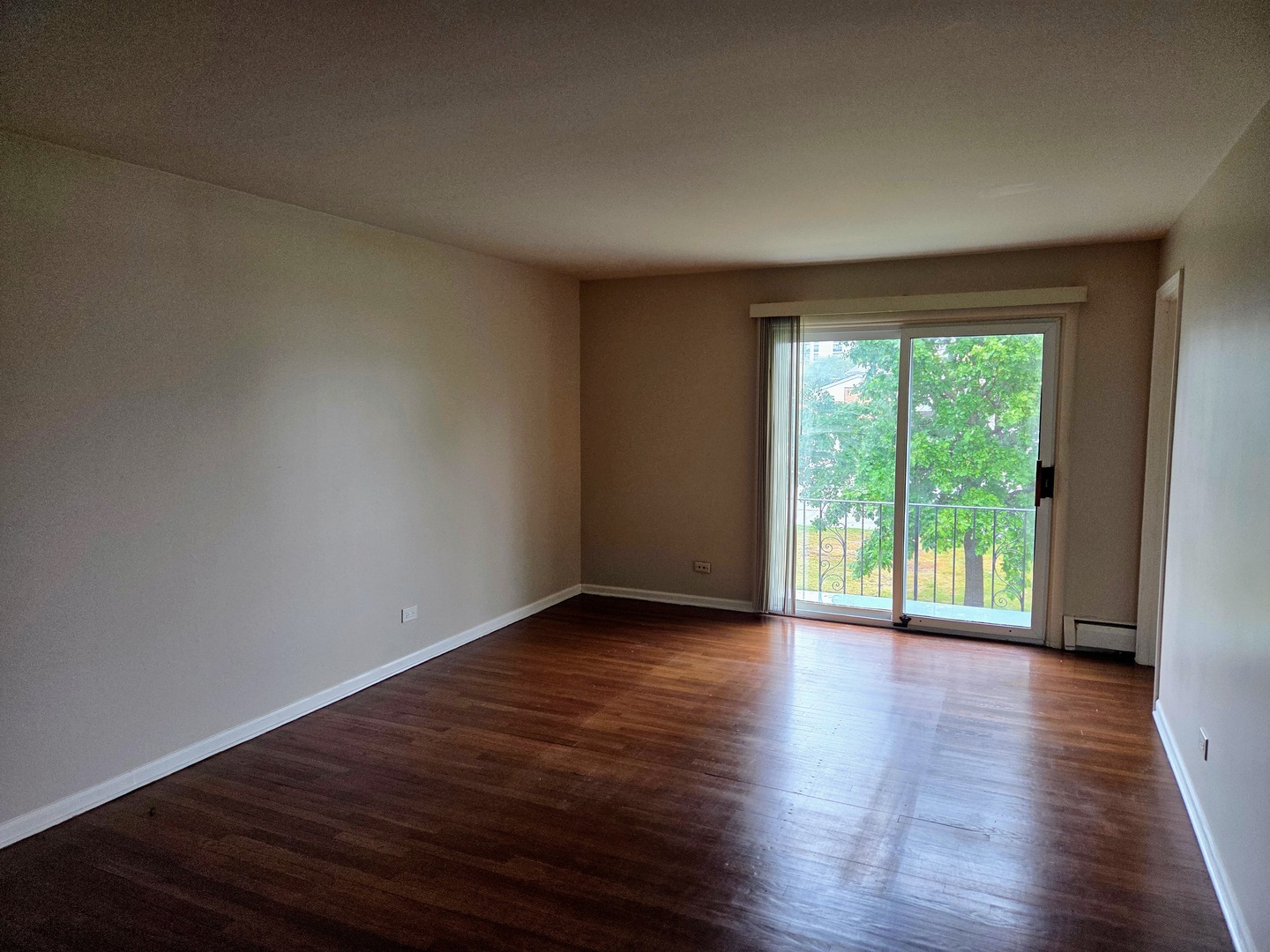 9561 Dee Road, Unit 2D Des Plaines, IL 60016 - Photo 2 of 9 a view of an empty room with wooden floor and a window