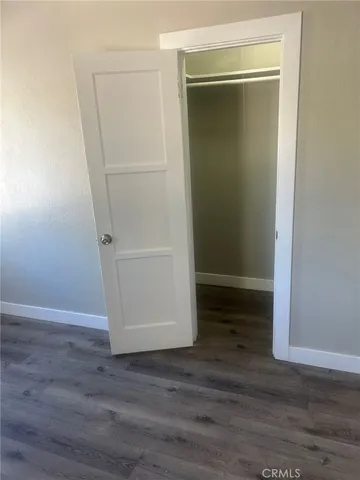 an empty room with wooden floor and closet