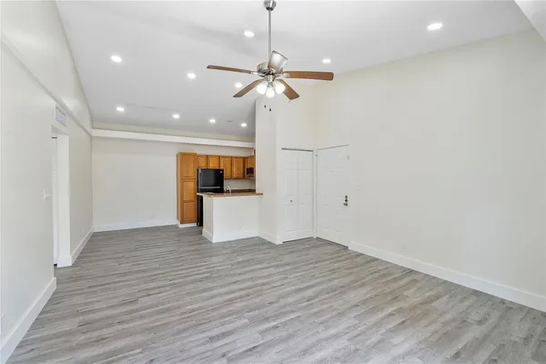 a view of a livingroom with a kitchen counter top space and wooden floor