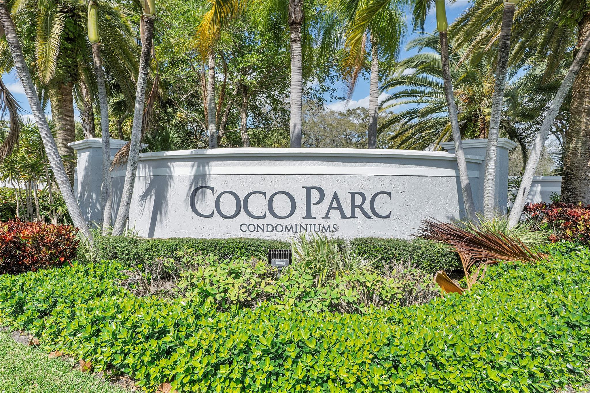 931 Lyons Road, Unit 4204 Coconut Creek, FL 33063 - Photo 13 of 17 a sign broad in front of flowers