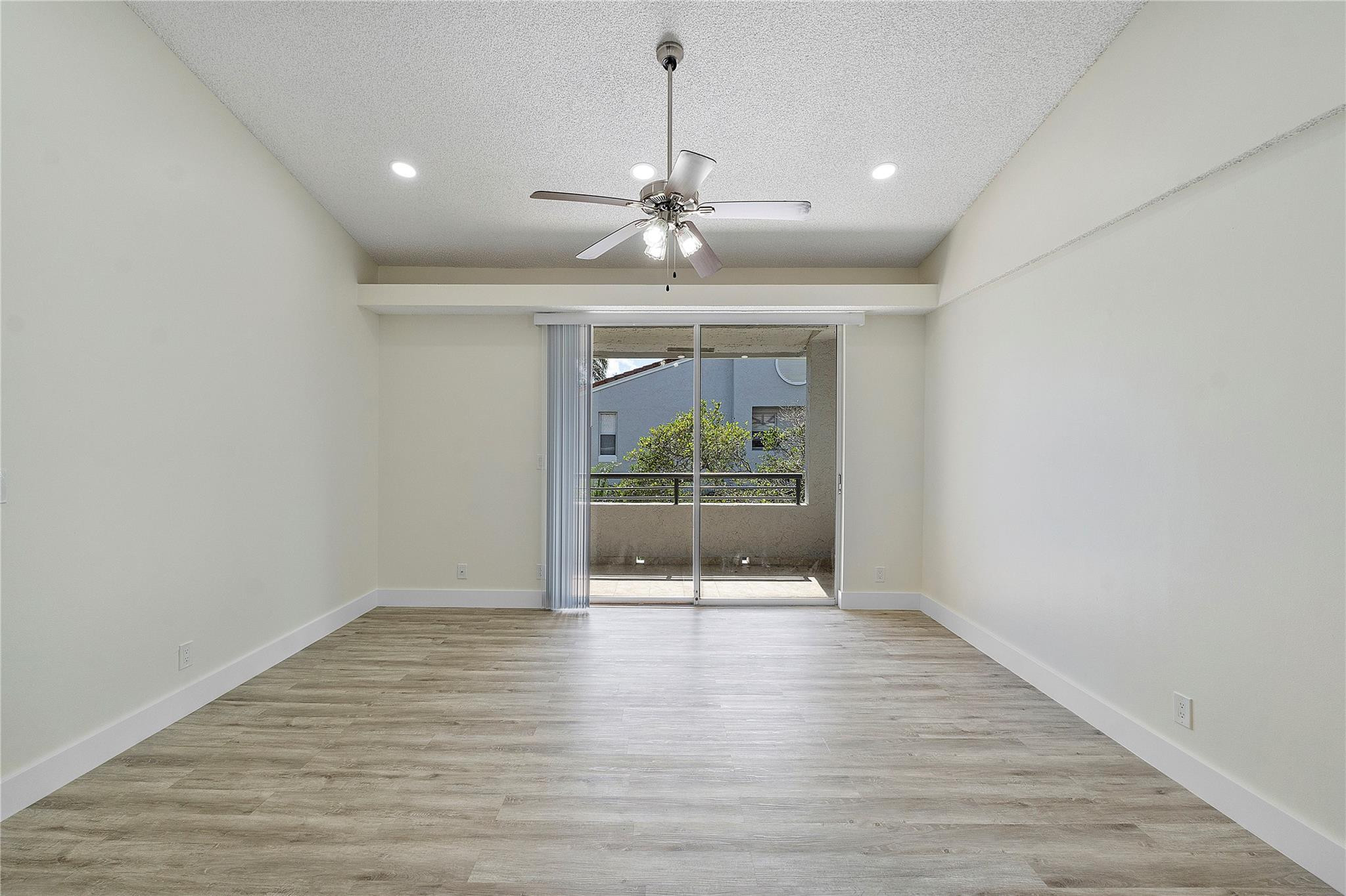 931 Lyons Road, Unit 4204 Coconut Creek, FL 33063 - Photo 2 of 17 a view of an empty room with a window and wooden floor