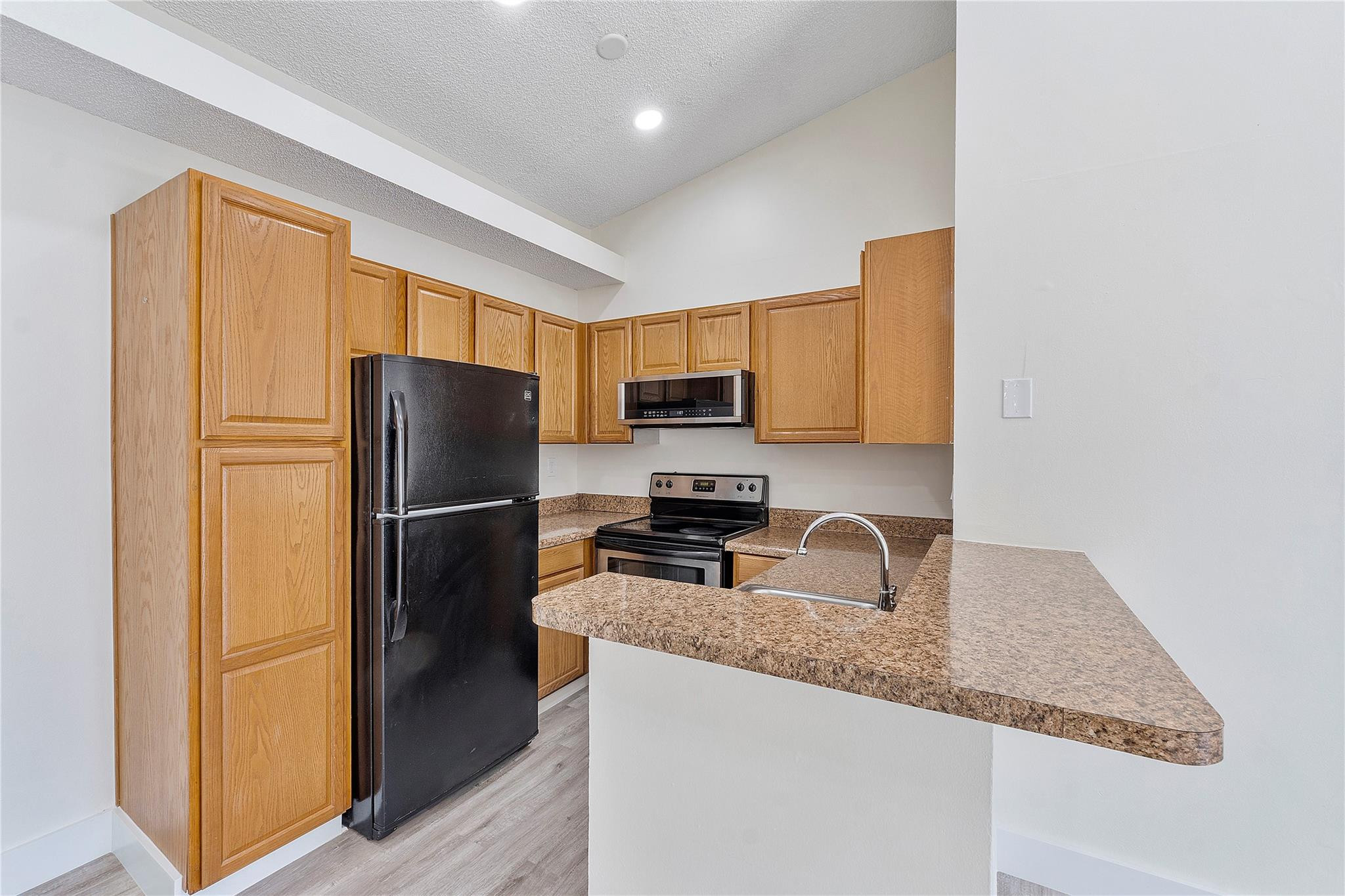 931 Lyons Road, Unit 4204 Coconut Creek, FL 33063 - Photo 3 of 17 a kitchen with granite countertop a refrigerator and a sink