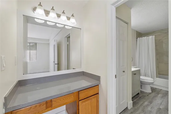 a bathroom with a sink vanity mirror and toilet