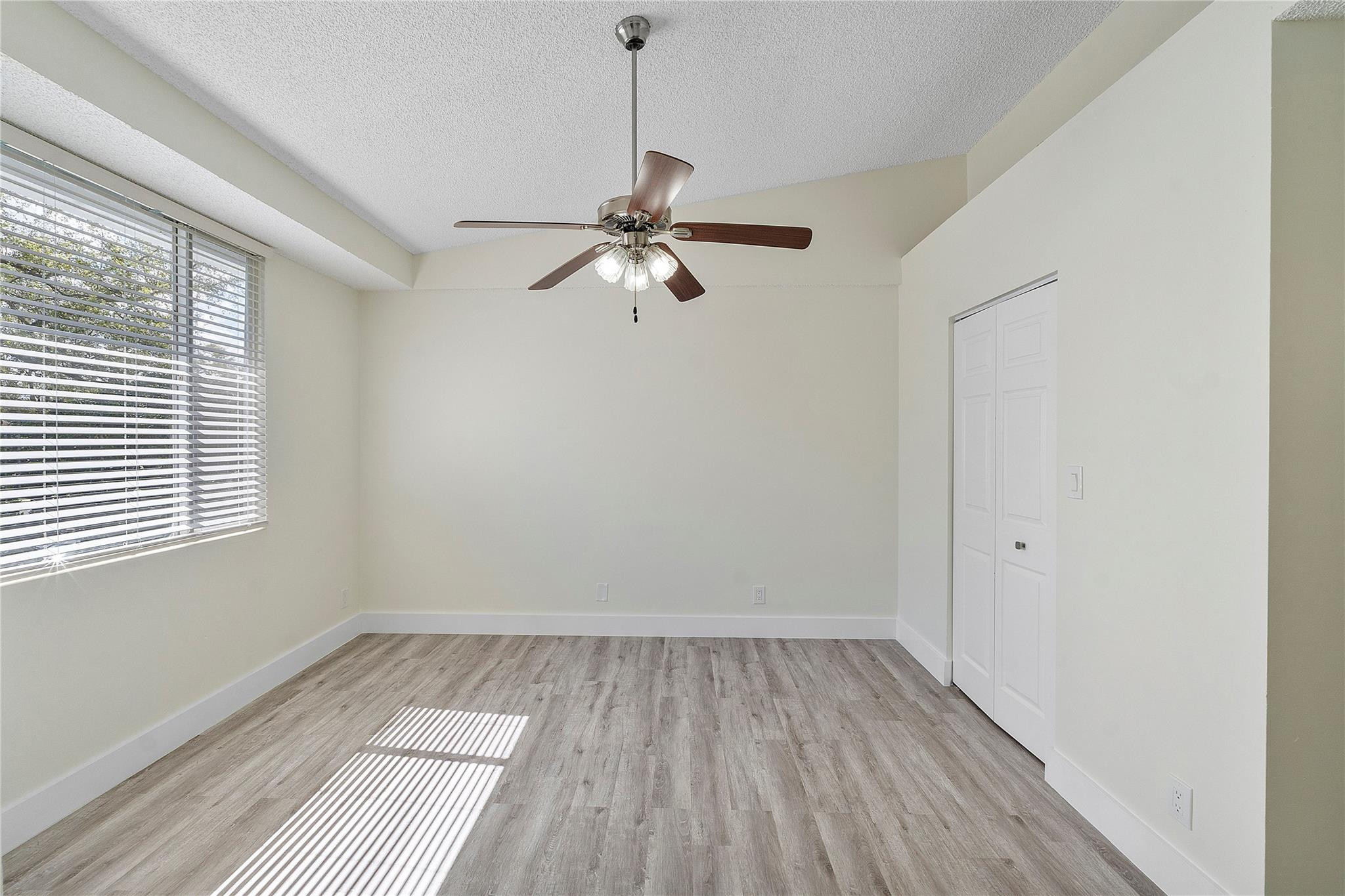 931 Lyons Road, Unit 4204 Coconut Creek, FL 33063 - Photo 8 of 17 wooden floor in an empty room with a window