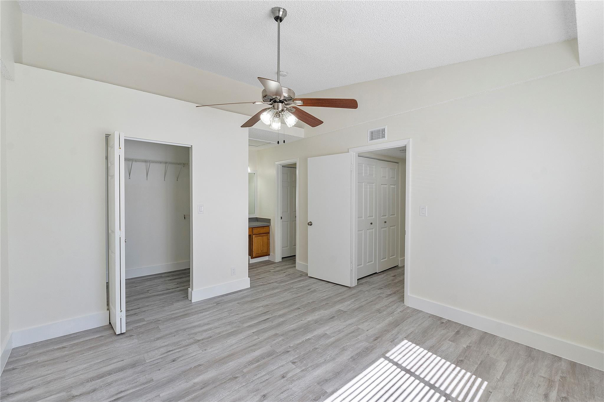 931 Lyons Road, Unit 4204 Coconut Creek, FL 33063 - Photo 9 of 17 a view of a room with wooden floor and a ceiling fan