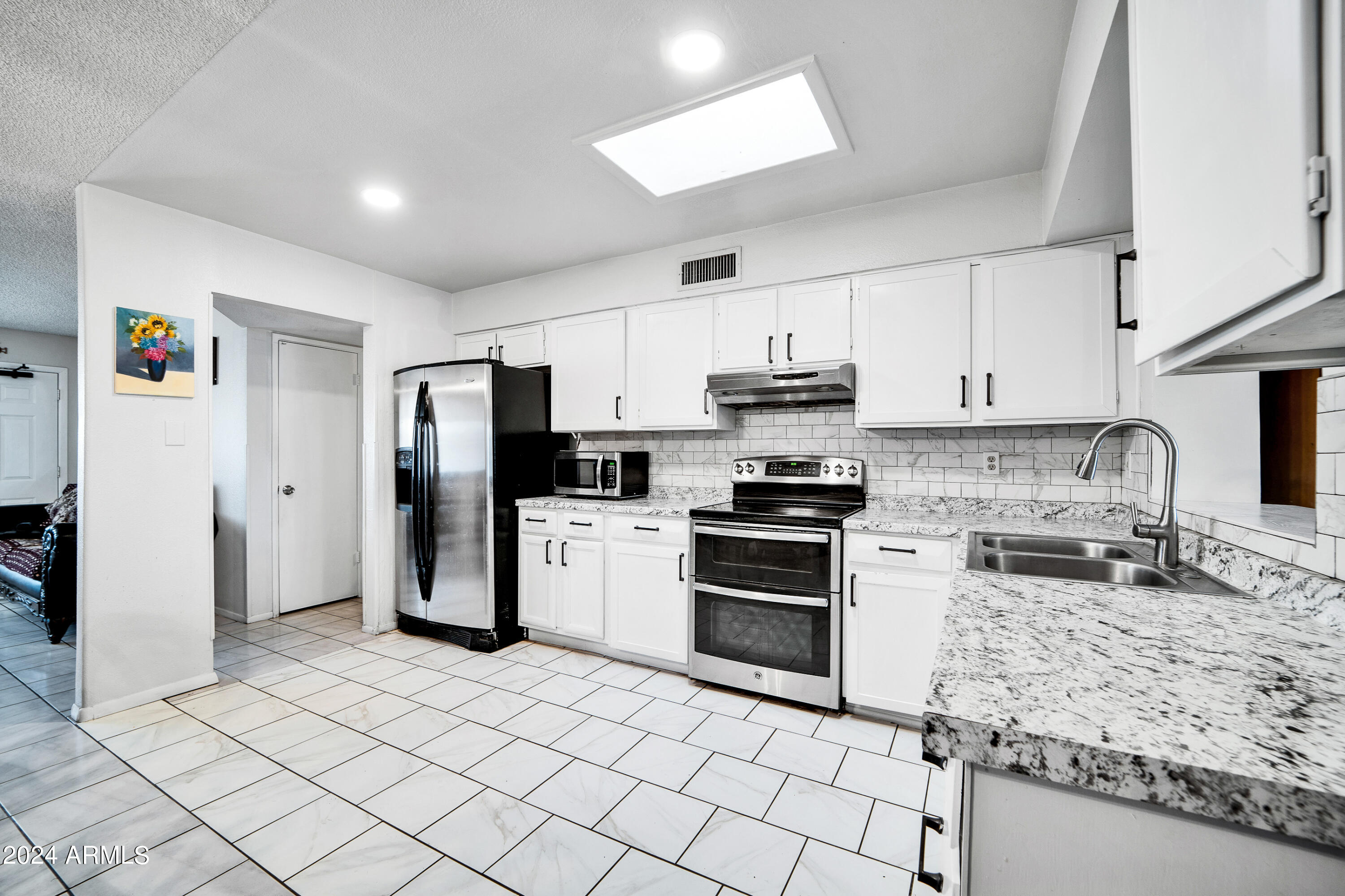7601 West Osborn Road Phoenix, AZ 85033 - Photo 12 of 37 a kitchen with granite countertop a refrigerator and a stove top oven