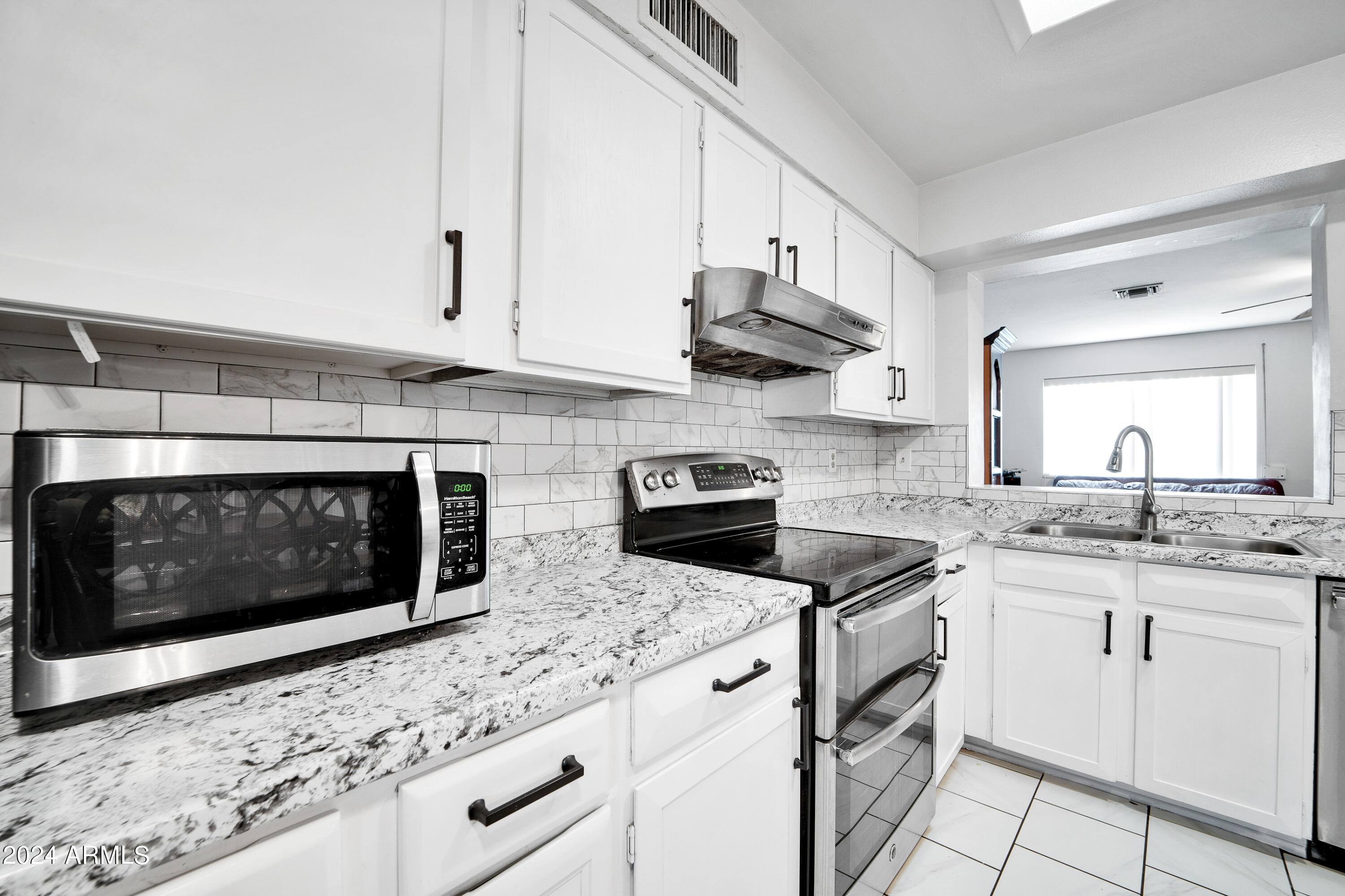 7601 West Osborn Road Phoenix, AZ 85033 - Photo 13 of 37 a kitchen with granite countertop white cabinets stainless steel appliances and a sink